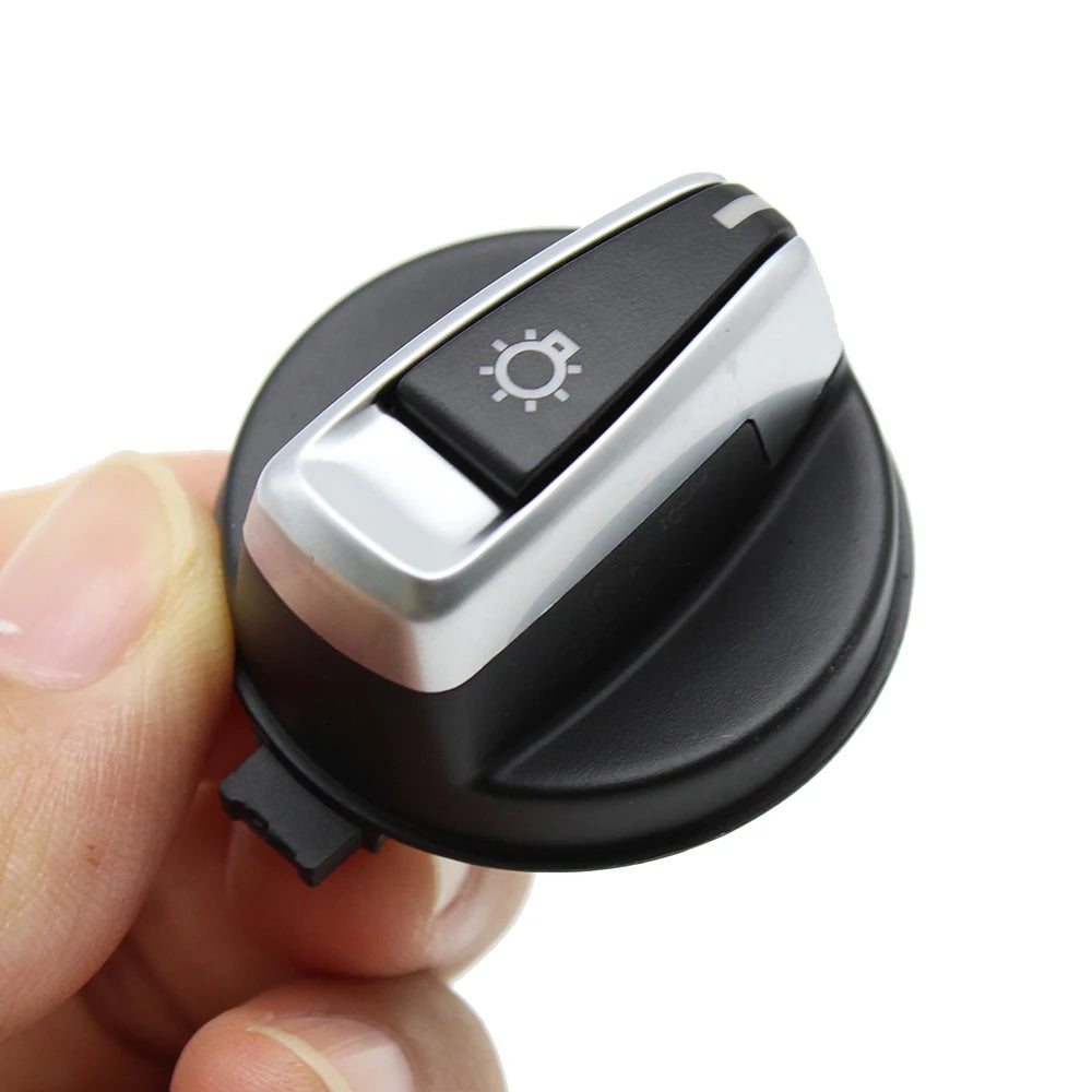 Bouton rotatif de commande des phares BMW présenté de face tenu en main