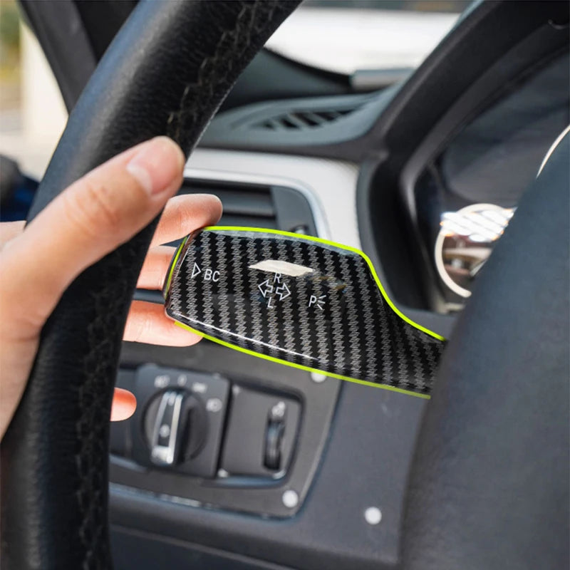 Positionnement du cache de commandes de volant BMW finition carbone sur la commande derrière le volant