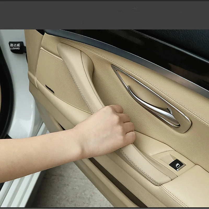 Garniture de poignée intérieure de porte BMW beige installée dans l’habitacle au niveau de la porte avant