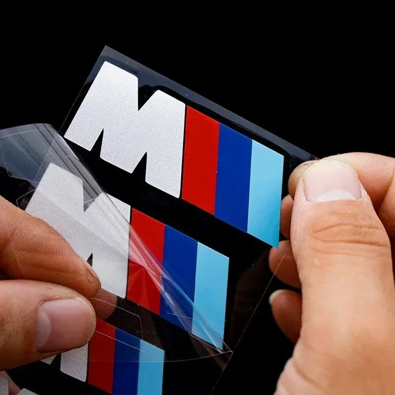 Pose manuelle des stickers logo M pour étriers de frein BMW sur fond noir