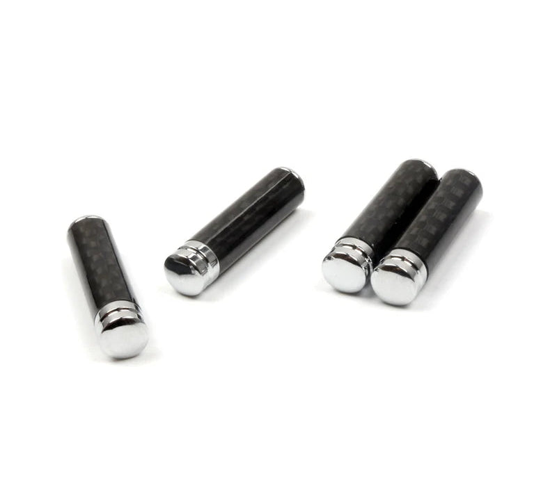 Trois boutons de verrouillage de porte aspect carbone présentés sur fond clair