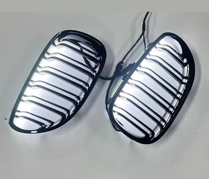 Calandres BMW noir brillant avec contour LED blanc allumé sur fond clair
