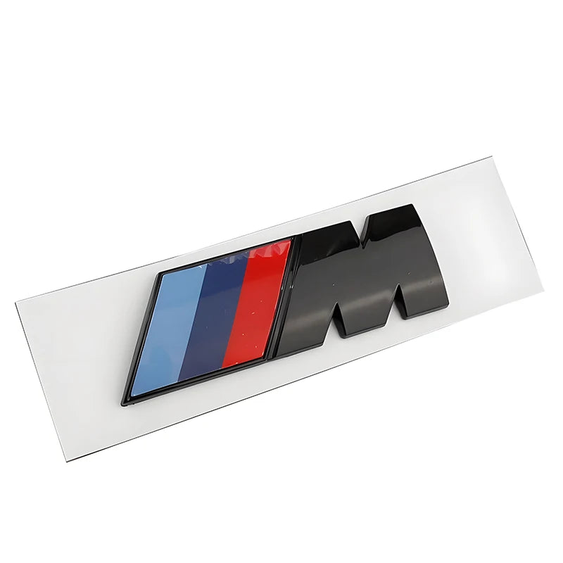 Logo BMW M Performance présenté seul sur son support blanc avant installation