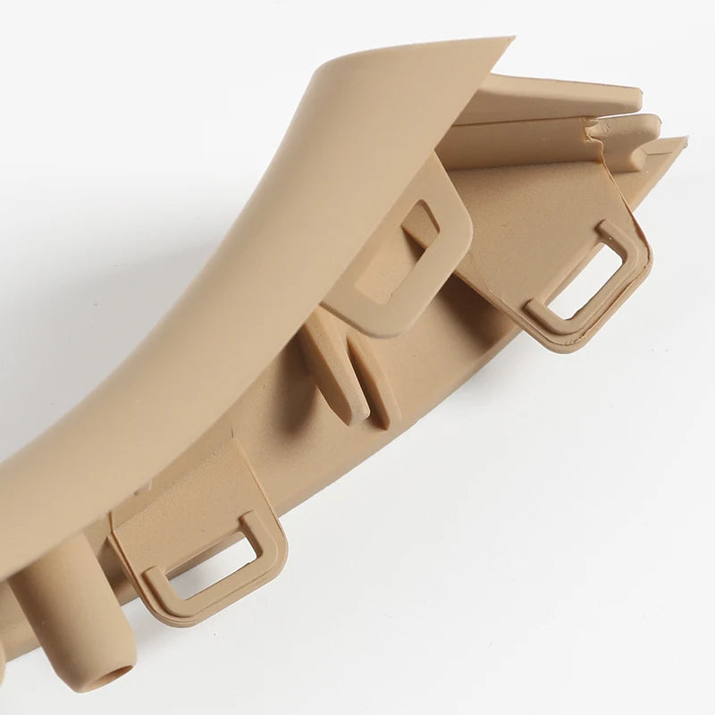 Détail d’une poignée intérieure beige BMW F10 F11 F18 avec clips et fixations visibles