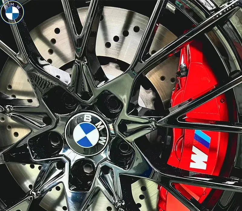 Stickers logo M montés sur étriers rouges visibles derrière une jante noire BMW