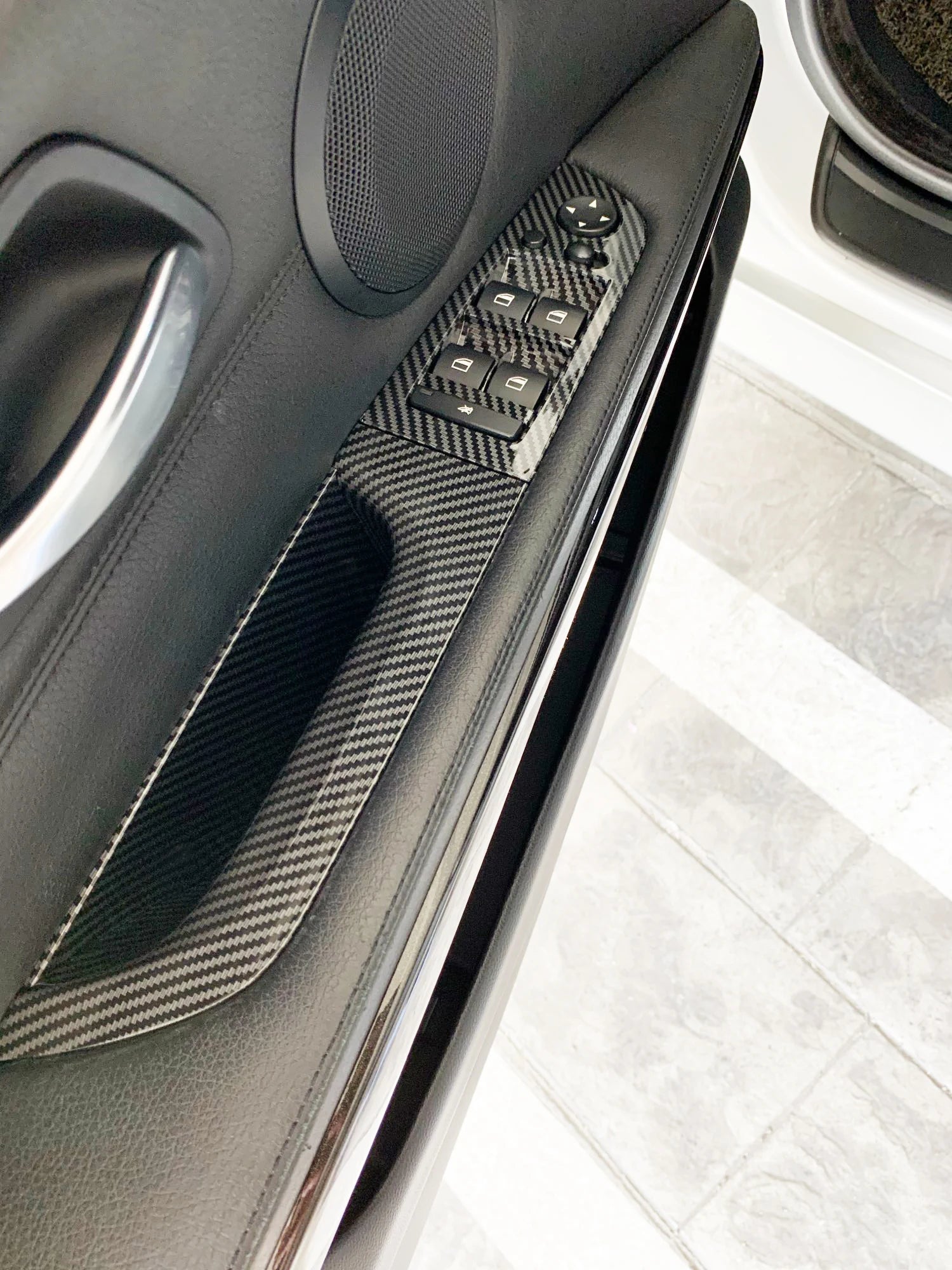 Poignée intérieure BMW E90 E91 aspect carbone montée sur panneau de porte noir